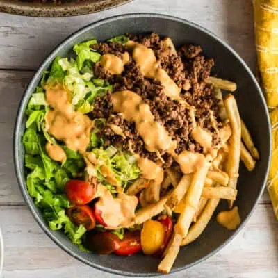Bowl filled with ground beef, fries, lettuce, tomato and special sauce.