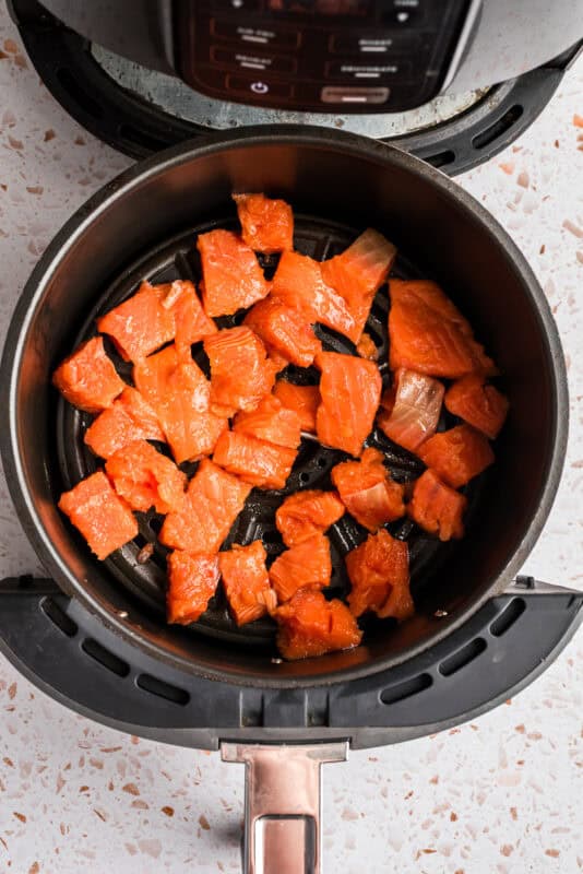 Salmon cubes in the air fryer basket.