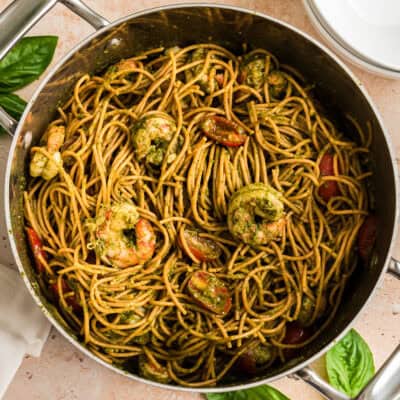 Large pot filled with pesto shrimp pasta.