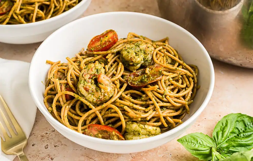Pesto shrimp pasta in a white bowl. 