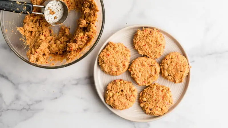 Chickpea fritters shaped on a white plate.