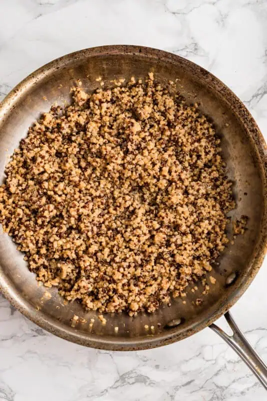 Multicolor quinoa being reheated in a pan.