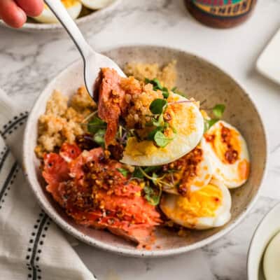 Forkful of smoked salmon, quinoa and eggs being lifted from bowl.