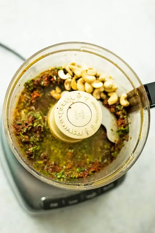 Cashews added to the sundried tomato and basil mixture in food processor.
