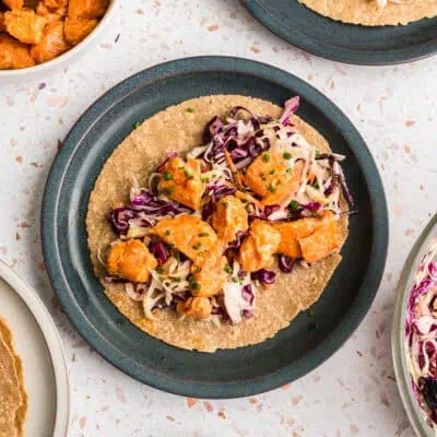 Open face buffalo salmon taco on a blue plate.